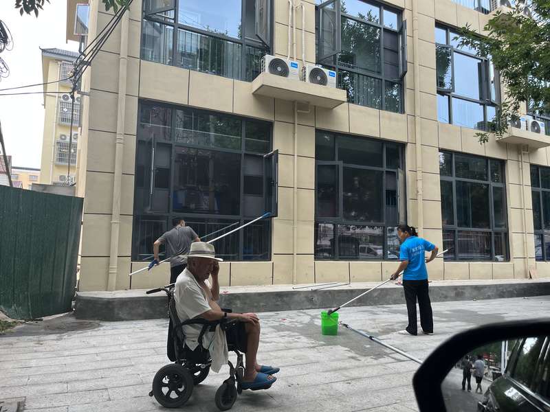 鹿邑社区沿街建筑外立面玻璃清洗,长杆工具作业,城市街道立面维护。