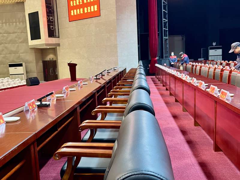 鹿邑县人大/政协会议会场保洁现场,红色座椅整齐排列,舞台背景庄重,高标准完成会场保障。