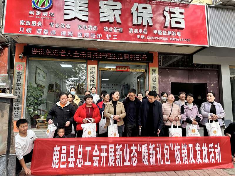 鹿邑县总工会在鹿邑美家保洁门店前开展新业态'暖新礼包'核销及发放活动，家政员领取工会福利。