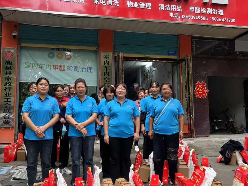 鹿邑美家保洁员工团队在鹿邑美家家政门店前合影，身穿统一蓝色工服，展现鹿邑家政服务团队风貌。
