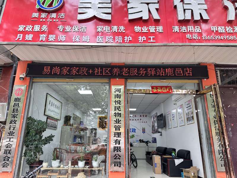 鹿邑美家保洁鹿邑门店实景,LED屏展示本地服务内容,门侧挂鹿邑县家政行业工会联合会牌子,鹿邑本土保洁服务门店。