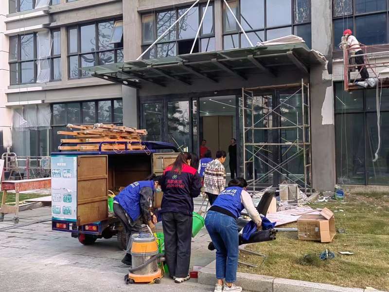 鹿邑新办公楼开荒保洁现场,鹿邑美家家政团队准备吸尘器、工具车,配合吊篮外墙作业。