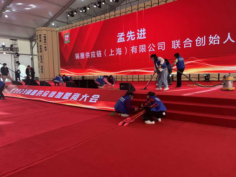 锅圈供应链(上海)有限公司大会现场全景,红色主题舞台与参会人员,鹿邑美家家政承担会场清洁服务,体现与锅圈集团的实质性合作。