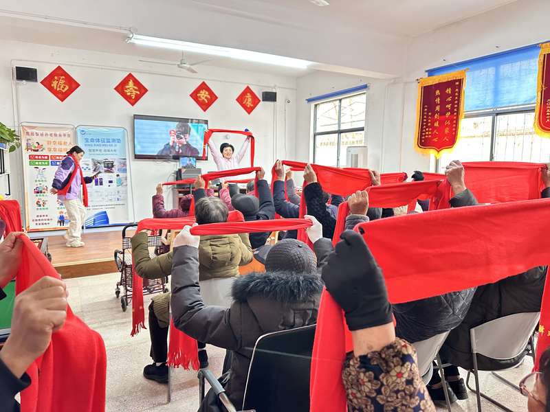 鹿邑智慧居家养老服务运营指挥中心开展老人集体健身操/互动活动,红围巾为统一标识。