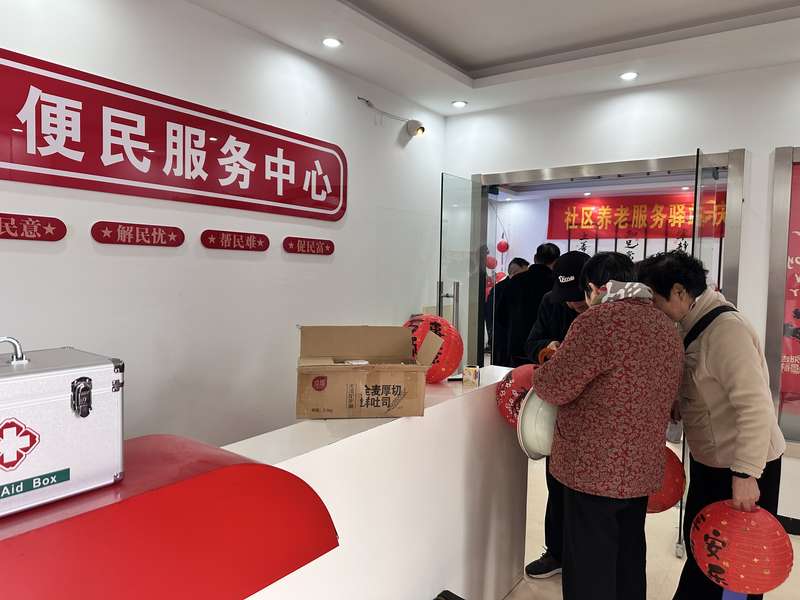 鹿邑东关社区便民服务中心与社区养老服务驿站相连,老人领取节日礼品。